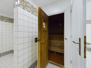 a wooden door in a bathroom with white tiles at null Haus Oland Whg 2 Südstrandkoje in Wyk auf Föhr