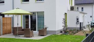 a patio with two chairs and an umbrella at Ein Haus zum Träumen in Bensheim