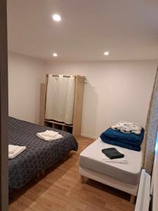 a small room with two beds and a window at Gîte des deux L 