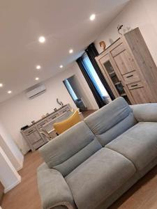 a living room with a couch and a kitchen at Gîte des deux L 