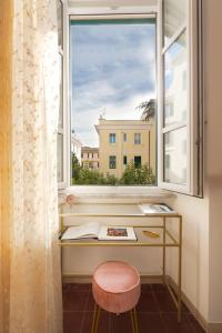 een raam met een bureau en een kruk voor een raam bij G & G Maisonette Testaccio in Rome