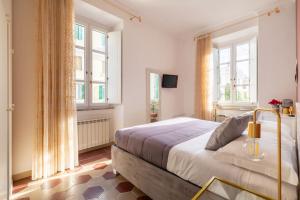 a bedroom with a large bed and two windows at G & G Maisonette Testaccio in Rome