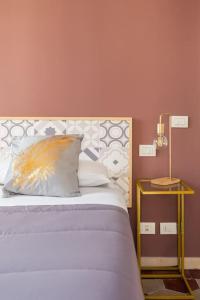 a bed with a pillow and a table with a lamp at G & G Maisonette Testaccio in Rome