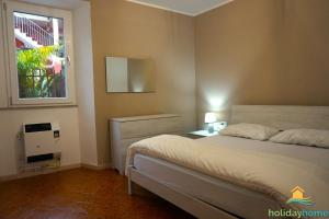 um quarto com uma cama branca e uma janela em La Tazza Verde em Arco