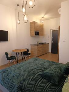 a bedroom with a bed and a table and a kitchen at MH Apartments in Rzeszów