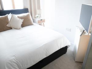a bedroom with a bed with white sheets and pillows at The Grand Serenity Suite in London