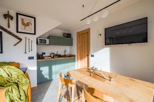 Hunum في Voga: مطبخ وغرفة معيشة مع طاولة خشبية