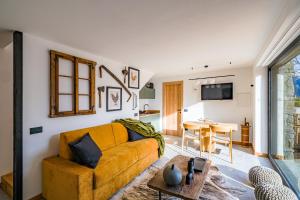 een woonkamer met een gele bank en een tafel bij Hunum in Voga