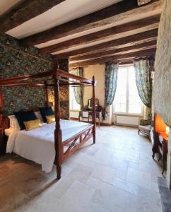 1 dormitorio con cama de madera en una habitación en Domaine de La Barde guest rooms and suites., en Le Bugue