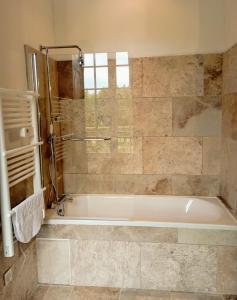 y baño con bañera y ducha. en Domaine de La Barde guest rooms and suites., en Le Bugue