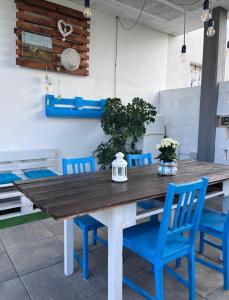 una mesa de madera y sillas azules en el patio en B&B La Casa in Campagna, en Collecorvino