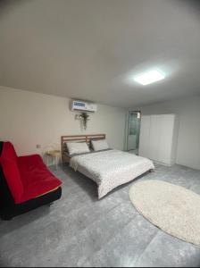 a bedroom with two beds and a red couch at استراحة الخيالة in Falaj al Mu‘allá