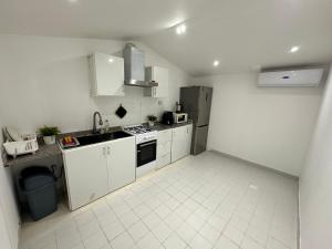 a kitchen with white cabinets and a refrigerator at استراحة الخيالة in Falaj al Mu‘allá