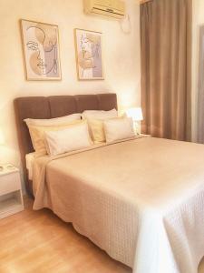 - une chambre dotée d'un grand lit blanc avec deux photos sur le mur dans l'établissement Apartments Franić, à Saplunara