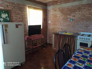 a kitchen with a refrigerator and a table with a television at Luna in Villa Cura Brochero