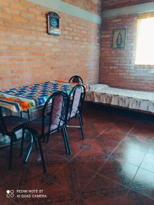 a table and chairs with a bench in a room at Luna in Villa Cura Brochero
