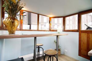 a kitchen with a counter with stools and a vase at Najade Eco Houseboat in Amsterdam