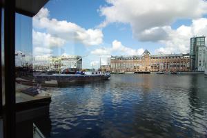 een uitzicht op een rivier met boten en gebouwen bij Najade Eco Houseboat in Amsterdam