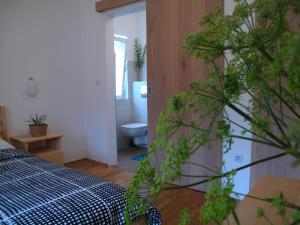 a bedroom with a bed and a bathroom with a toilet at Guesthouse Bor Plitvice Lakes in Plitvička Jezera
