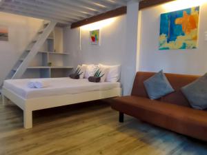 a bedroom with a white bed and a couch at Coco Cavana Resort in Batangas City