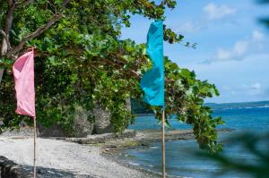 two flags on a beach next to the water at Coco Cavana Resort in Batangas City