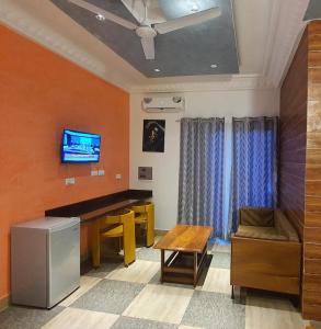 ein Wohnzimmer mit einem Schreibtisch und einem TV in der Unterkunft Résidence abdou diouf in Dakar