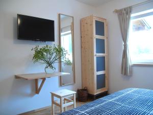 a bedroom with a bed and a tv on a wall at Guesthouse Bor Plitvice Lakes in Plitvička Jezera