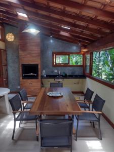 a dining room with a wooden table and chairs at CASA PRUMIRIM in Ubatuba