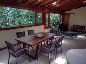a dining room with a wooden table and chairs at CASA PRUMIRIM in Ubatuba