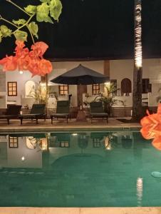 a pool with chairs and an umbrella at night at White Coconut Resort in Gili Trawangan