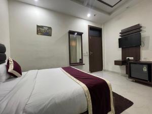 um quarto com uma cama e uma televisão em Hotel AS Royal em Agra
