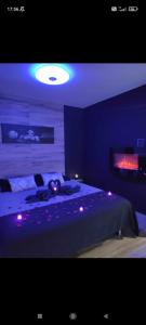 Un dormitorio con una cama con luces moradas. en Loft sauna jacuzzi ospariegeois, en Lavelanet