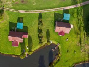 an aerial view of houses in a field with water at Lake Naverone Holiday Cottages in Drakensberg Garden