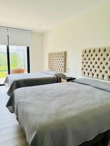a bedroom with two beds and a window at 2BR Apartamento Moxie Paracas con Terraza y AC en 1r Piso in Paracas
