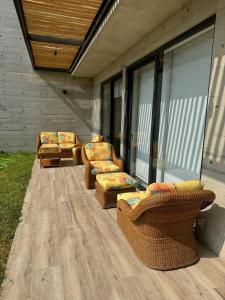 um grupo de cadeiras e mesas num pátio em 2BR Apartamento Moxie Paracas con Terraza y AC en 1r Piso em Paracas