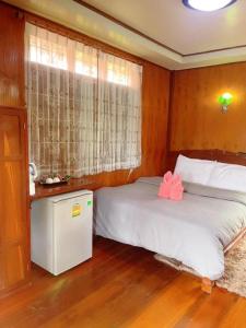 Un dormitorio con una cama con un arco rosa. en Bunraksa Resort en Kamphaeng Phet