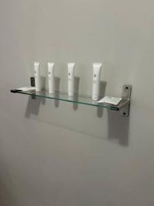 a glass shelf with cups on a white wall at Hillsview, Roodepoort in Roodepoort