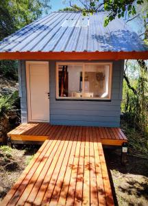 a tiny house with a tin roof on a deck at Cedro Azul in La Cumbre