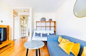 a living room with a blue couch and a tv at Charming apartment, sleeps 4- 15 mins to Central in London