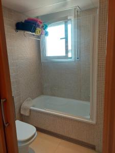 ロスピタレート・デ・リンファントにあるOliveres IIIのバスルーム(バスタブ、トイレ付)、窓が備わります。
