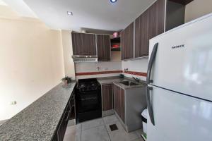 une cuisine avec des armoires en bois et un réfrigérateur dans l'établissement Patagonia Home - New and spacious, à Ushuaia