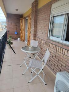 einen Tisch und zwei Stühle auf einer Terrasse in der Unterkunft Departamentos Don Guillo in Alta Gracia