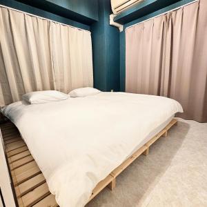 Cama grande en habitación con cortinas en ueno minowa 502, en Tokio