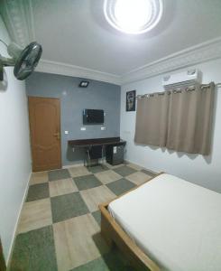a bedroom with a bed and a desk in it at Résidence abdou diouf in Dakar
