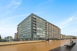 Appartement aan Zee Oostende في أوستند: مبنى طويل على الممشى في المدينة