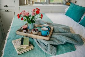 a tray of eggs and flowers on a bed at Blatchford Briar - Award Winning Private Shephards Huts with their own Secluded Hot Tubs in Milton Abbot