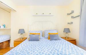 a bedroom with a blue bed with two lamps at Charming apartment, sleeps 4- 15 mins to Central in London