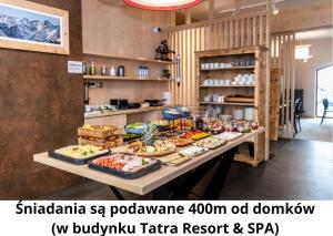 una mesa con muchos tipos diferentes de comida en ella en Czarne Wierchy Domy Premium, en Kościelisko