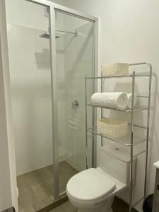 a bathroom with a toilet and a glass shower at Departamento de Estreno SEMREQ in Piura
