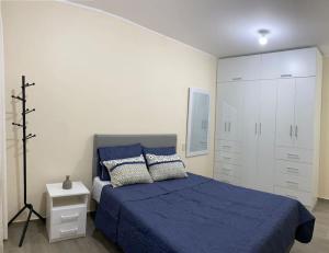 a bedroom with a blue bed and white cabinets at Departamento de Estreno SEMREQ in Piura